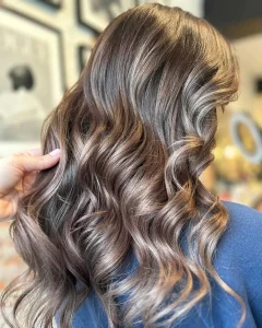 Dimensional brown balayage with caramel and honey blonde highlights on long wavy hair by Elevate Beauty Lofts Etobicoke Toronto